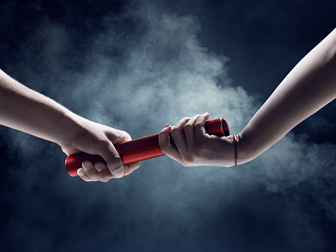Close up of exchanging relay baton on a race