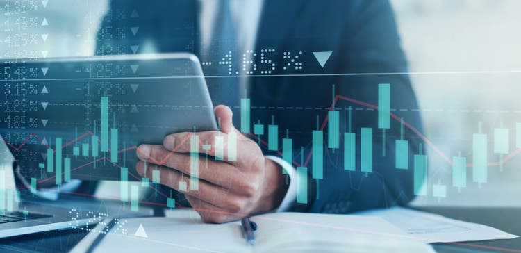Digitally enhanced shot of an unrecognizable businessman using a tablet superimposed over a graph showing the ups and downs of the stock market