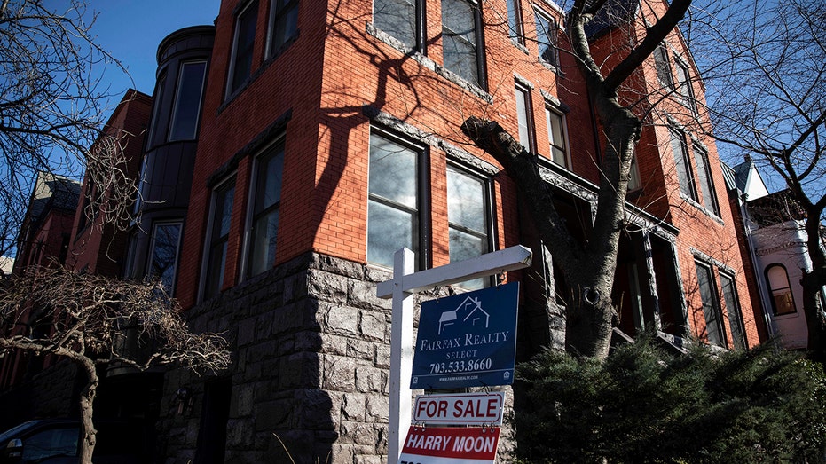 for sale sign posted in front of apartment complexes